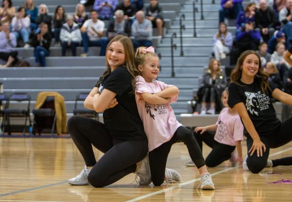 Freshman Annie Cole performs with a participant of the Pup Pack dance clinic during the annual Husky Hoops Invitational.  