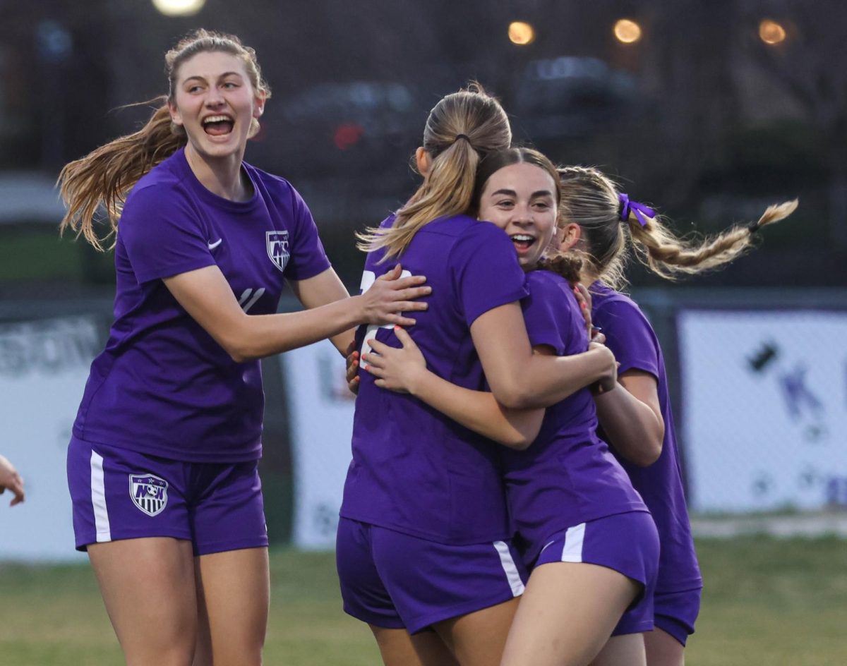 Players+on+the+soccer+team+celebrate+with+senior+Kate+Rooney+after+she+scores+the+first+goal+during+their+game+against+Olathe+South+on+March+21.+%E2%80%9CI+think+we+were+all+waiting+for+the+first+goal+to+realize+we+can+score+and+we+can+do+this%2C%E2%80%9D+Rooney+said.+The+Huskies+went+on+to+win+against+the+Falcons%2C+3-0.+%0A