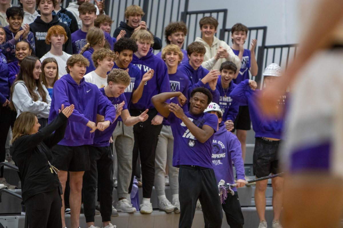 At a boys varsity basketball game, senior Trey Ridley leads the student section in celebration. “When people actually show up and cheer for our team it makes for a fun student section,” Ridley said. 