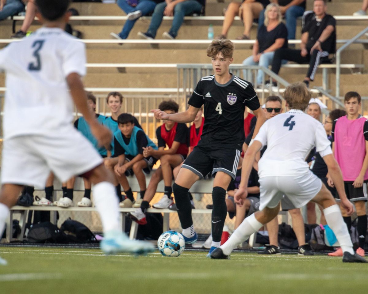 Sophomore Rogen Anderson passes the ball through Blue Valley North's defense. The game ended with a score of 0-0. "A tie isn't what we were hoping for, but we weren't unhappy with our performance," Anderson said. He stated that the team hopes to gain momentum from this match and begin a strong season.