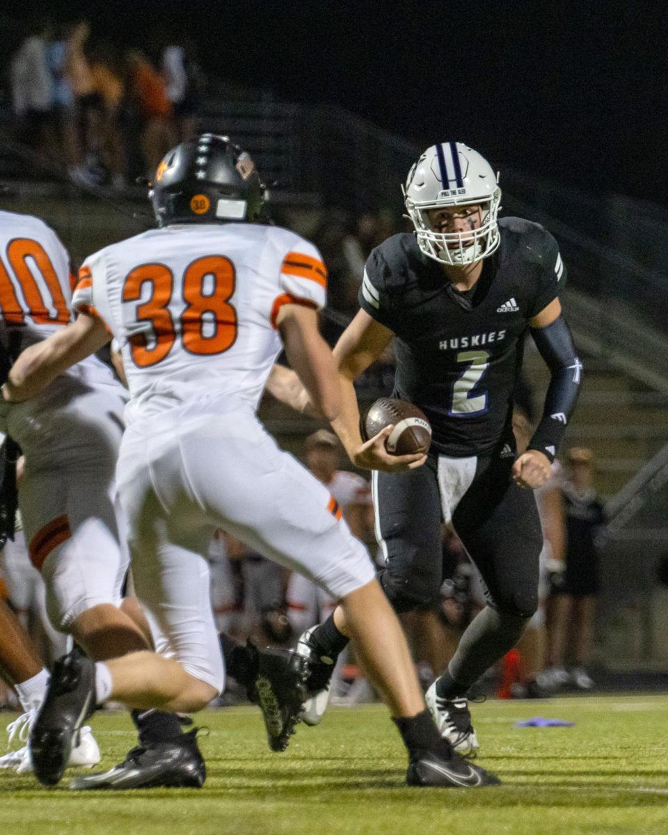 Senior Ford Bevins plays quarterback against Shawnee Mission Northwest Sept. 13. “Football is important to me because it is a way to decompress and spend time with friends,” Bevins said. “I’m proud of how I grew as a person because of football.”