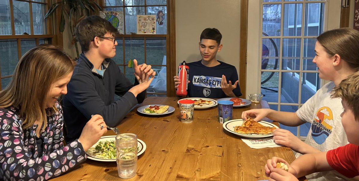 
Freshman Abraham Gutierrez, center, eats dinner with the Hare family, who is hosting him while he plays for Sporting Kansas City March 9. Senior Hayden Hare said Gutierrez is like a brother. "We joke around, play video games and do everything we’d normally do as a family. It doesn’t feel like we’re hosting him—it just feels like he’s part of us," Hare said. 