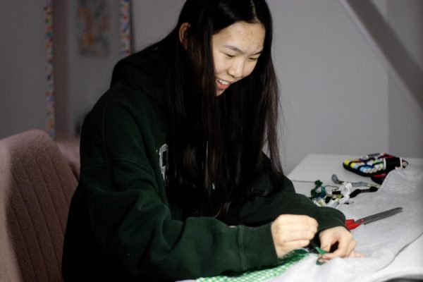 Ellie Xu sews her design onto a sweatshirt March 6. “My favorite part of making clothes is seeing people’s reactions when they first see the final product,” Xu said.