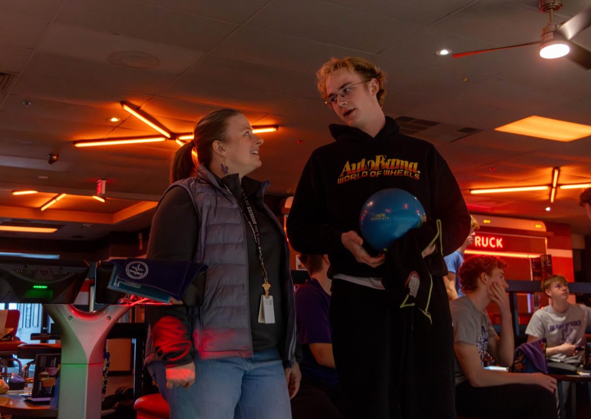 Bowling Coach Kerry Kinkelaar gives her son, junior Larson Kinkelaar, instruction on his bowling technique. ”Larson and I are close, so it's fun to get to see that piece of his world with a different perspective than a lot of normal parents,” Kerry said.
