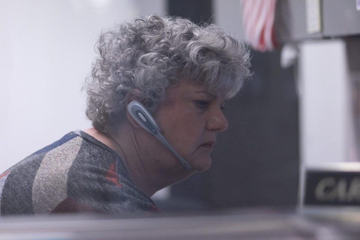 On a quiet morning, Carol Hess is seen typing on her computer after attending to late arrivals. 