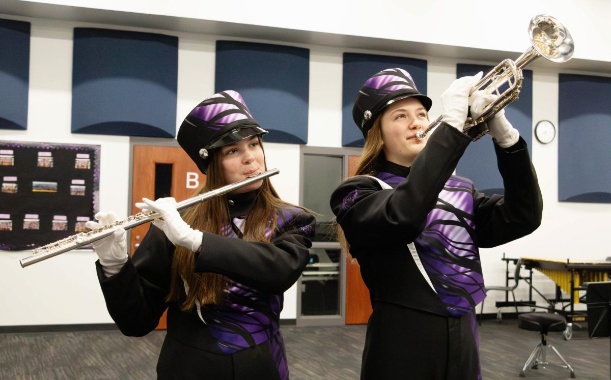 (Photo Illustration) Alongside fellow band member, Adeyln Dillavou (left), Charlotte Norton (right) holds her trumpet in a displayed position. “My favorite part about being in band is the fact that I have 160 other friends,” Norton said.